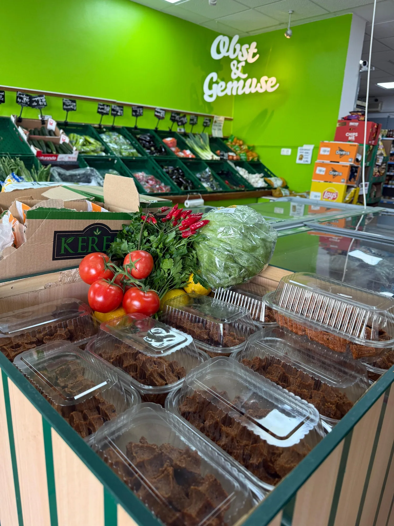 Vorbereitungsbereich mit frischen Çiğköfte-Trays und Gemüse