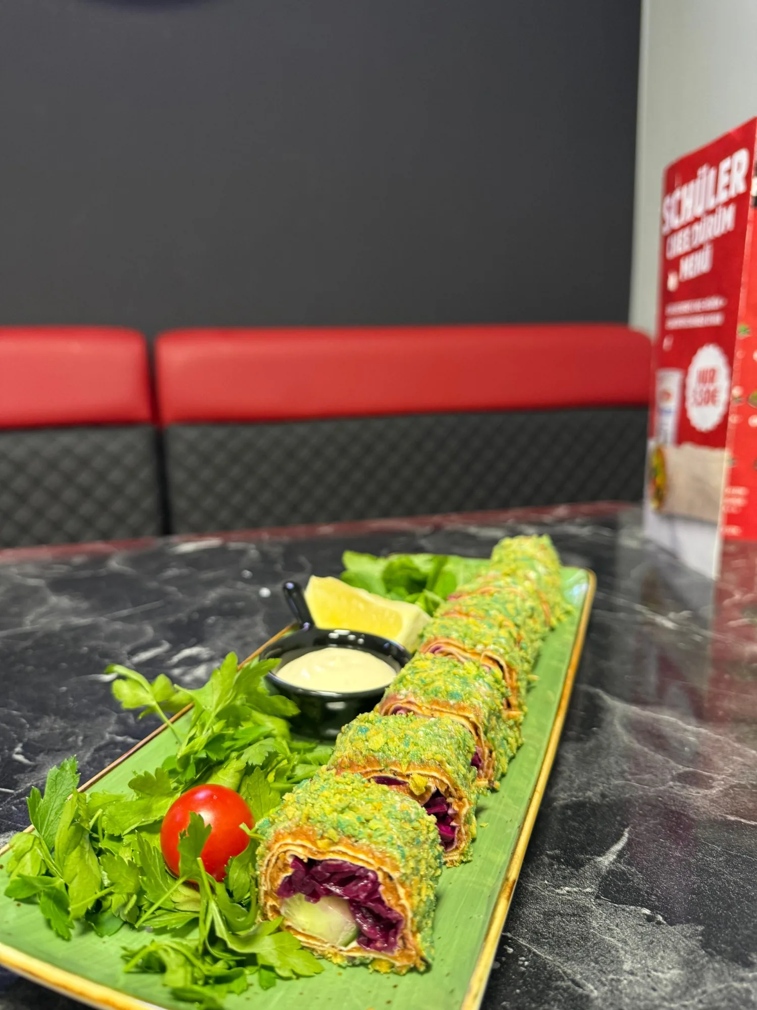 Lange Sushi-Çiğköfte-Rolle mit Dip auf Bananenblatt